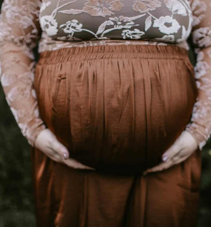 pregnant-woman-holding-her-tummy-standing-near-green-leaf-1525389 pregnant-woman-holding-her-tummy-standing-near-green-leaf-1525389